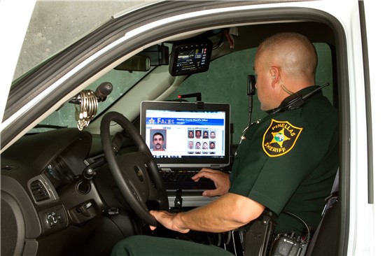 Photo of Deputy inside vehicle with laptop